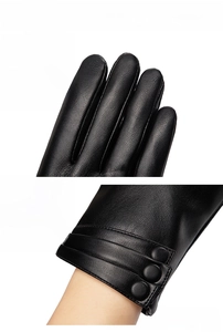 Detail of black PU leather gloves featuring lychee texture and decorative wrist buttons