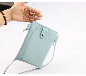 Détail d'un sac de téléphone en cuir PU bleu clair avec bouton pression et anneau en métal