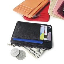 Detail of black leather wallet with coin zipper and card slots featuring embossed logo