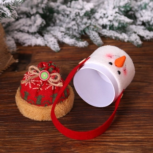 Christmas snowman plush gift bucket with red knitted drawstring lid and handle on wood