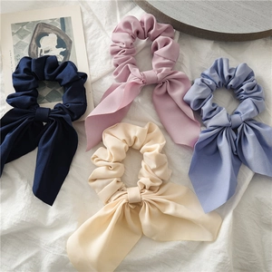 Detailed view of four soft chiffon bow scrunchies in navy blue, pink, blue and cream white