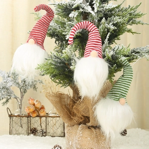 Détail de trois gnomes de Noël lumineux suspendus à un sapin avec décorations hivernales