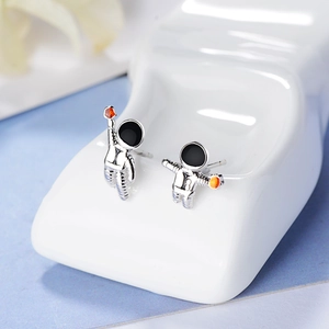 Astronaut asymmetrical stud earrings in silver metal with planet and star elements