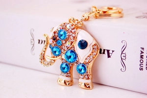 Detail of crystal elephant keychain featuring blue rhinestones on a gold metal finish