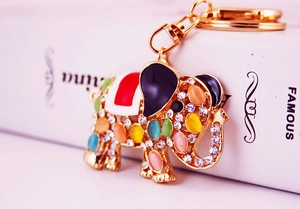 Close-up of golden elephant keychain with colorful opal stones and rhinestone inlay