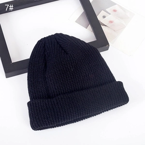 Detailed view of black knitted beanie with thick ribbed texture and wide fold-over cuff