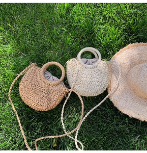Detailed view of handmade woven straw beach bag with round handles and strap for summer.