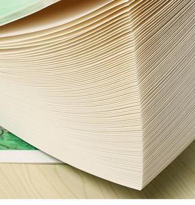 Macro shot of thick cream-colored sketchbook pages showing paper texture and density