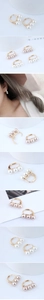Detail showing three pearls set in a gold-tone C-shaped hoop earring on model ear