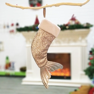Golden mermaid tail Christmas stocking with beige plush cuff hanging on tree