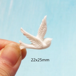 Macro shot of 22x25mm white resin swallow bird charm for DIY jewelry making
