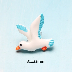 Close-up of a white and blue resin seagull charm with dimensions 31x33mm for DIY
