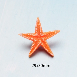 Detail of orange resin starfish charm for DIY crafts measuring 29x30mm on blue background