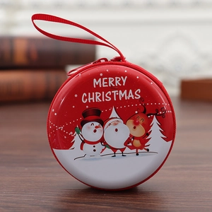 Close-up of red tinplate Christmas coin purse with snowman and Santa patterns
