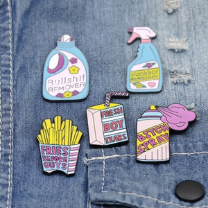 Detailed close-up of five colorful enamel pins styled on a blue denim jacket pocket