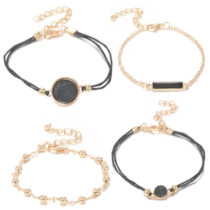 Detailaufnahme eines 4er-Armband-Sets mit schwarzen Seilen und goldenen Gliederketten