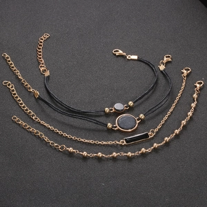 Detailansicht des 4er-Sets mit schwarzen Kordelarmbändern und goldenen Perlenketten