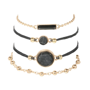 Detail eines 4-teiligen Boho-Armband-Sets mit goldenen Metallketten und schwarzen Perlen