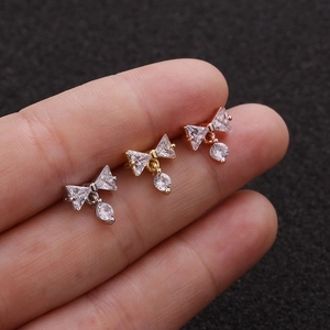 Bowknot zircon stud earrings in silver gold and rose gold on fingertips