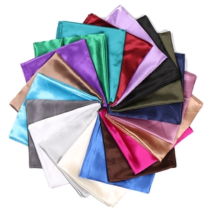 Macro display of assorted satin square scarves showing smooth glossy texture and vibrant colors