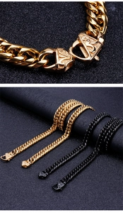 Close-up of gold and black Cuban chain necklaces with ornate engraved clasps on fabric