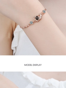 Close-up of heart projection bracelet in rose gold finish with zircon accents on wrist