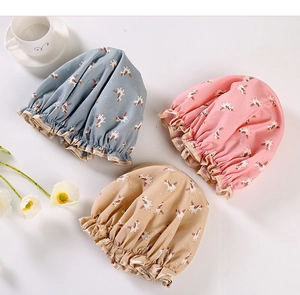 Detailed view of waterproof unicorn print shower caps in blue-grey, pink and beige