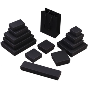 Set of black kraft paper jewelry boxes with matching gift bags on white background