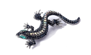 Detailed close-up of crystal lizard brooch with blue and rainbow rhinestones on silver base