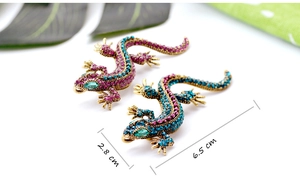 Macro shot of two gecko brooches with colorful rhinestones measuring 2.8 by 6.5 centimeters