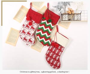 Detailed view of red and white knit Christmas stockings with reindeer patterns and pom-poms