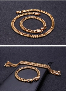 Close-up of golden Cuban link chain set with lobster clasp on a dark textured background