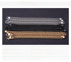Close-up of three men's stainless steel Cuban chain bracelets in silver, gold and black