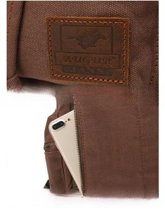Detail of vintage canvas backpack with leather logo patch and anti-theft back pocket
