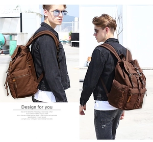 Brown canvas backpack with leather straps shown on a male model in an urban outdoor setting