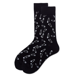 Detail of black mid-calf socks featuring white safety pin patterns on a plain background