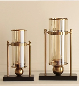 Detailed set of two gold metal and glass candle holders with matte black rectangular bases