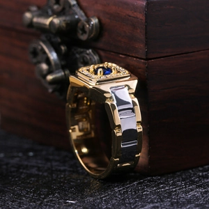 Macro detail of men's gold ring with square blue gemstone on a vintage wood box