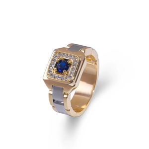Detail view of gold men's ring with a large blue gemstone and sparkling micro diamonds