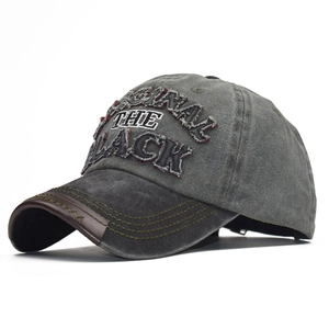 Detailed texture of charcoal cotton twill with vintage embroidery and leather brim accent