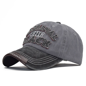 Detail of vintage washed baseball cap featuring BLACK embroidery and distressed leather brim