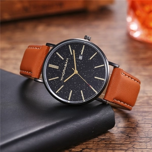 Business men's quartz watch with star sky dial and brown leather strap on a desk