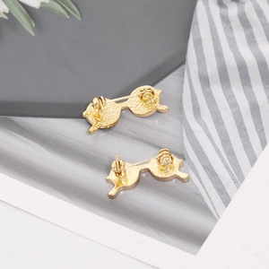 Detail view of golden sunglasses brooch back showing secure safety pin clasp mechanism