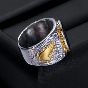 Macro shot of 21mm cross ring featuring golden praying hands and vintage textures