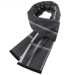 Detail of dark grey plaid scarf showing soft fabric texture and fringe tassels