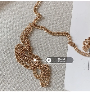 Nahaufnahme einer robusten goldenen Metallkette auf strukturiertem Stoffhintergrund