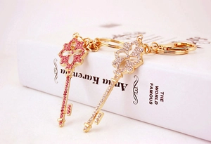 Close-up of heart shaped keychains with pink and white rhinestones and gold plating