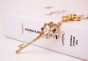 Close-up of golden four-leaf clover key pendant with polished hollow metal patterns