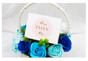 Close-up of woven flower basket with blue soap roses and Happy Every Day greeting card