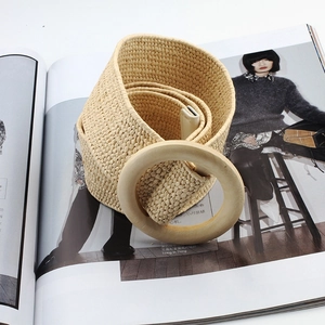 Detail of straw woven belt with round wooden buckle on a fashion magazine background